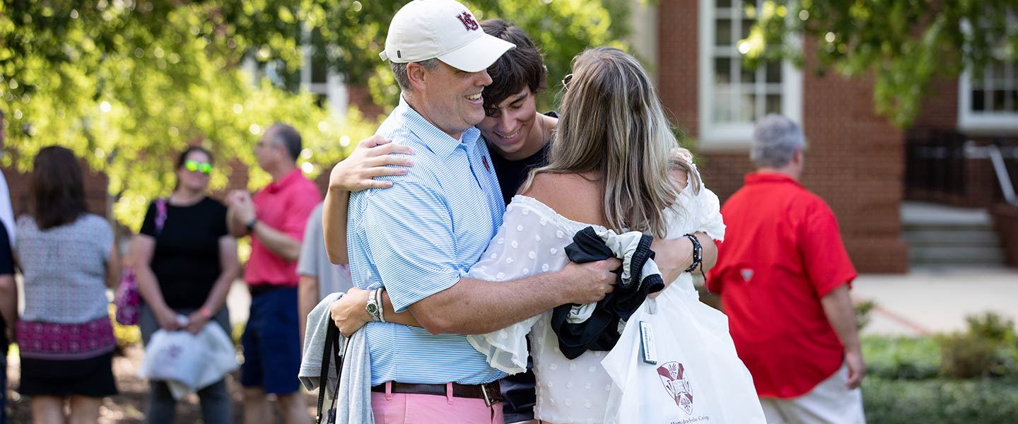 Family hugging goodbye at orientation