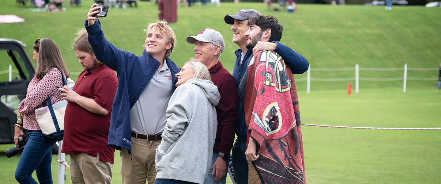 Family taking a selfie together on the football sideline