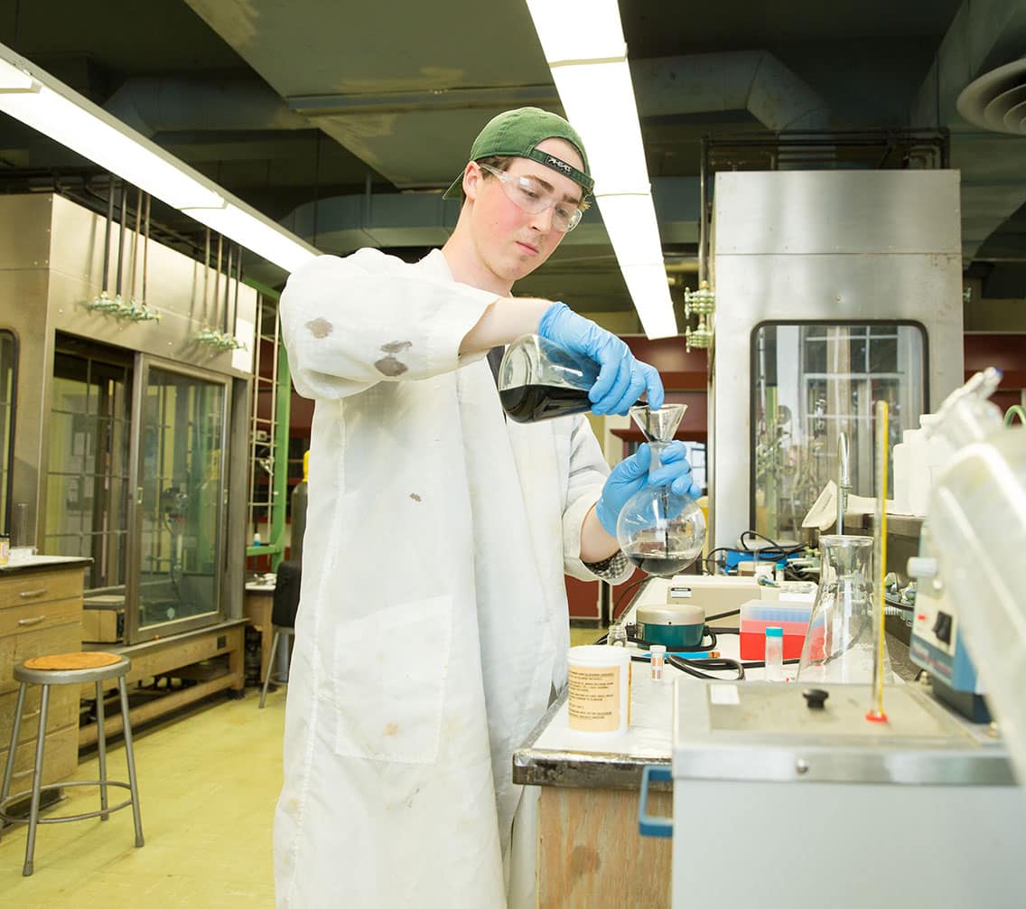 Charlie Wolfe pouring substance into a beaker