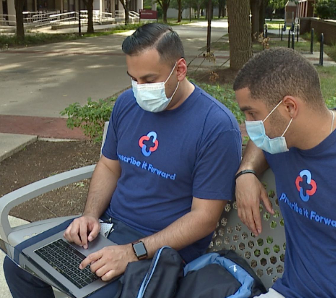 Aaron Gilani sitting on a park bench with a laptop