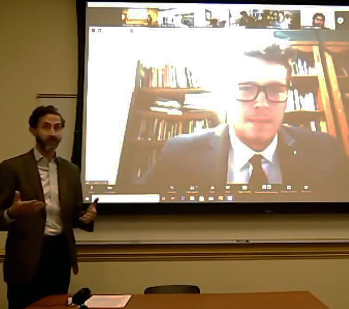 Andrew King presenting in front of a projector screen 