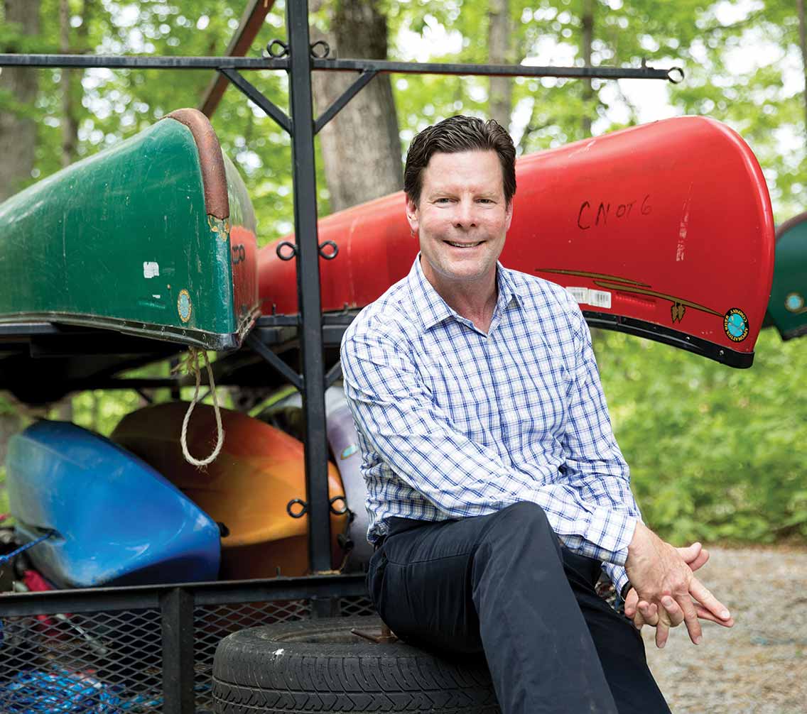 Director of High Adventure Scott Schmolesky sitting with a canoe rack