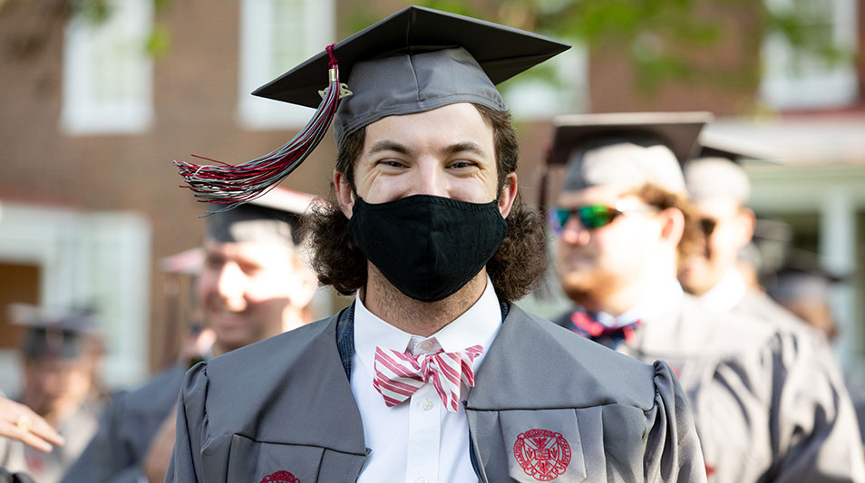 Hampden-Sydney student in regalia, mask, and bowtie smiling