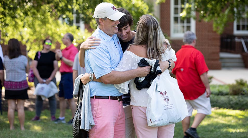 A family hugs as they say goodbye to their freshman student