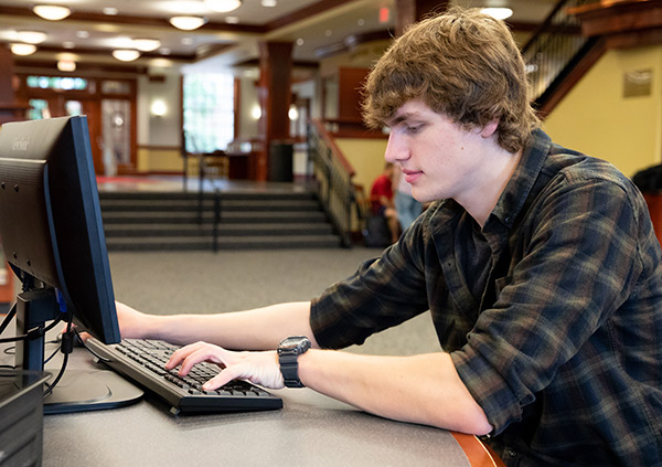 Student sitting at a computer doing research