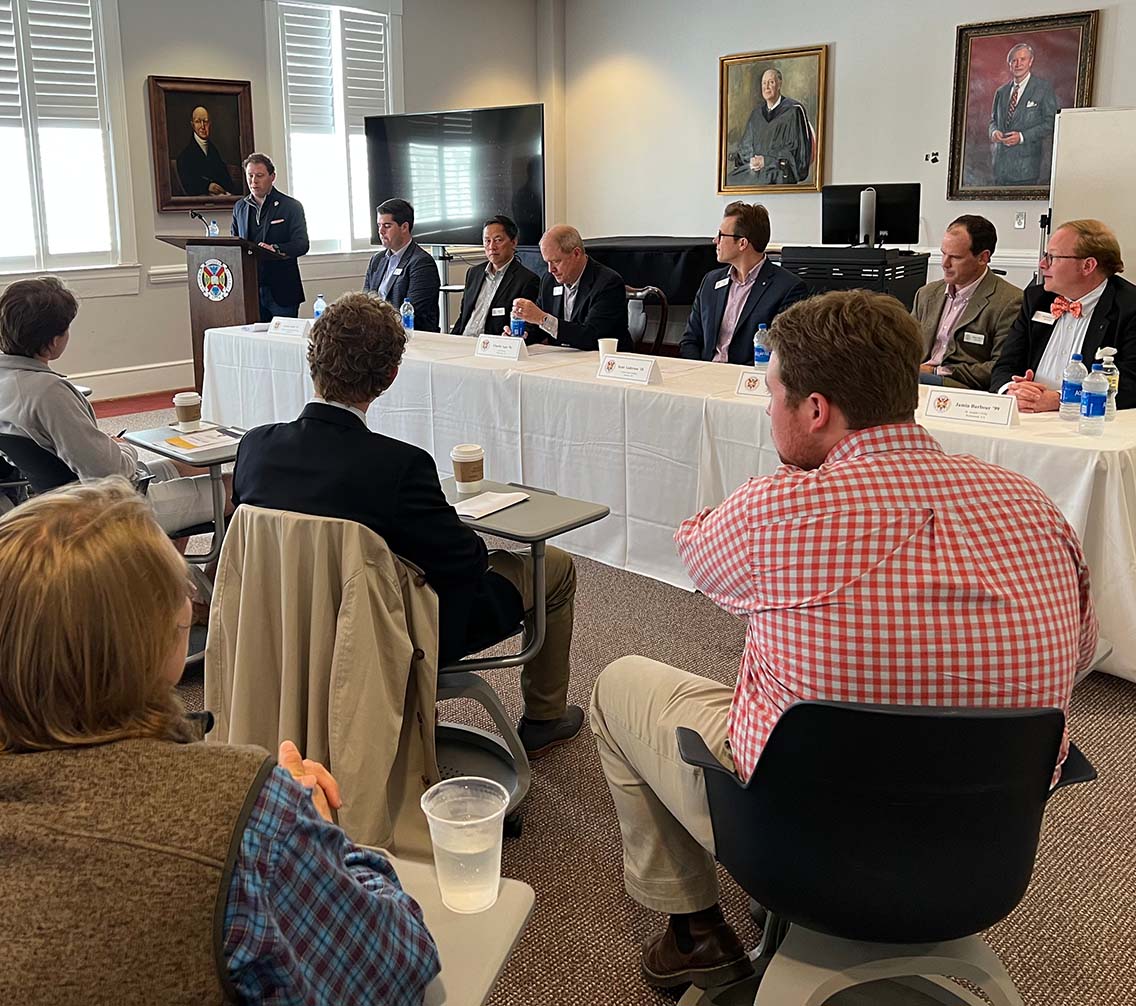 Alumni guest speakers sit on a panel in front of a student audience