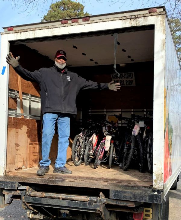 a volunteer stand in a truck full of donations