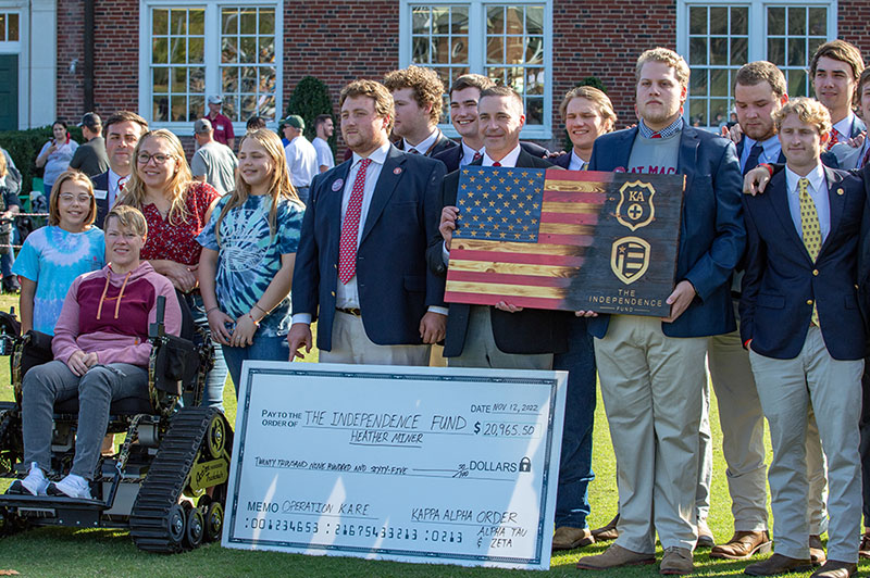H-SC fraternity brothers surround Haether Miner, wounded warrior, sitting in her new track chair