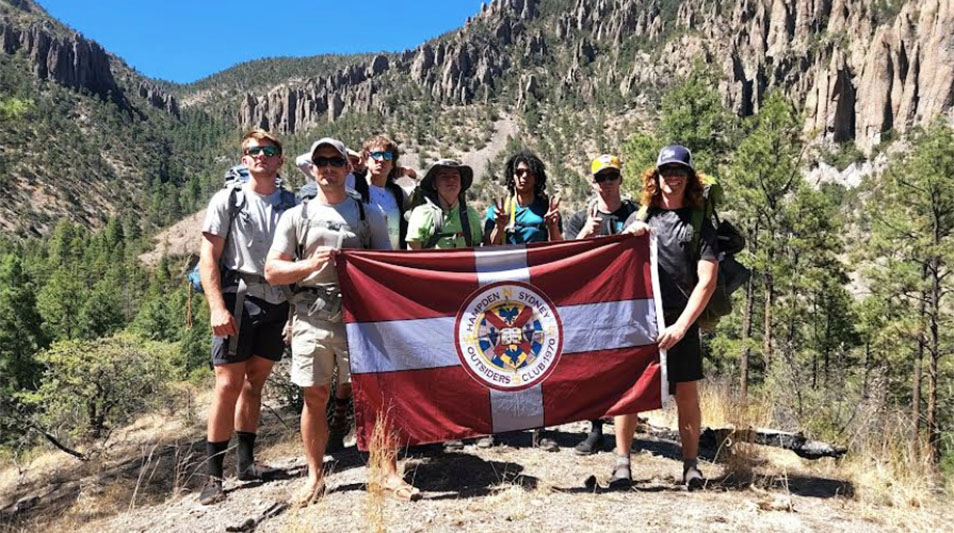 Hampden-Sydney students holding an H-SC flag while backpacking in the Gila Wilderness