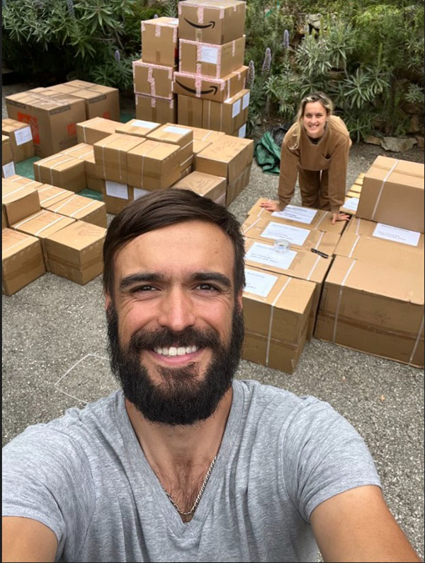 Yevhen (Zhenya) Goncharov posing in front of stack of Amazon.com boxes