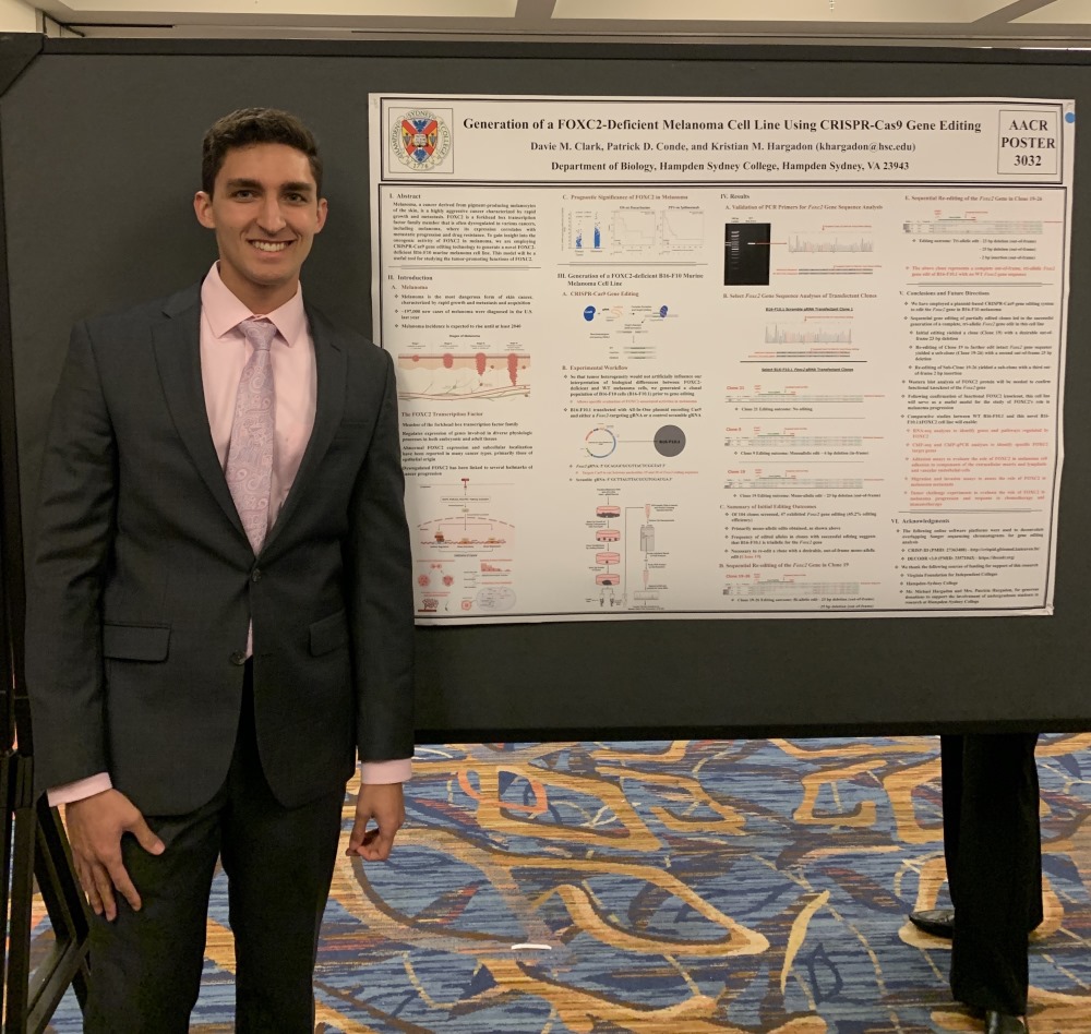 H-SC students standing beside his poster presentation
