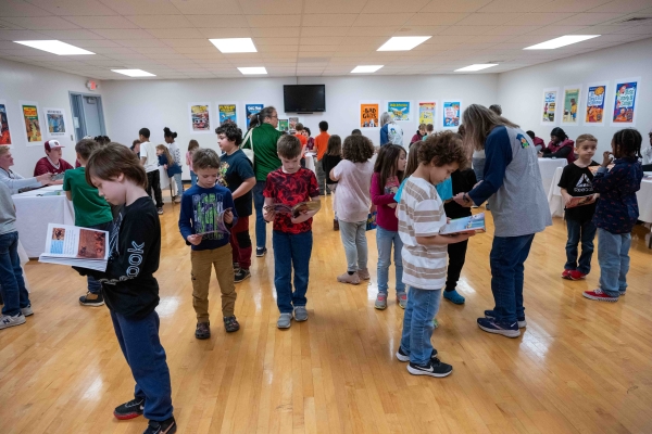 children filling a room looking at their new books