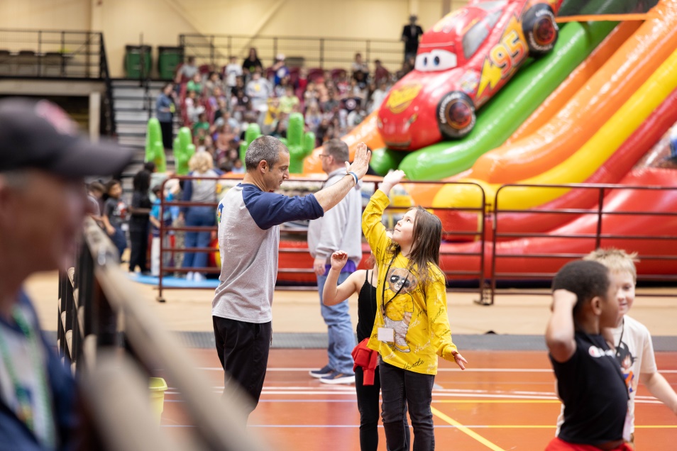 elementary students playing on a blow-up slide