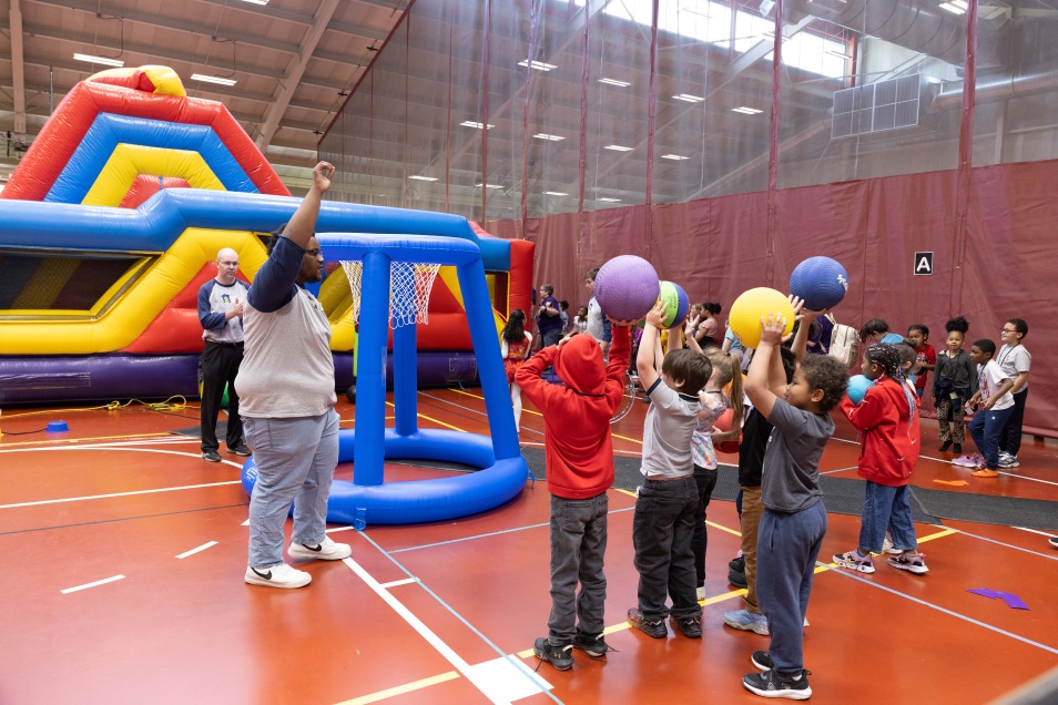 elementary students playing ball games in the gym