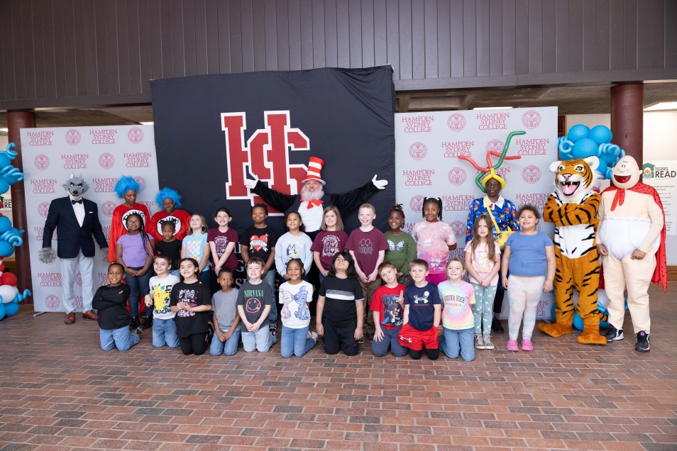 Dr Seuss characters and a group of elementary students posing for a group photo