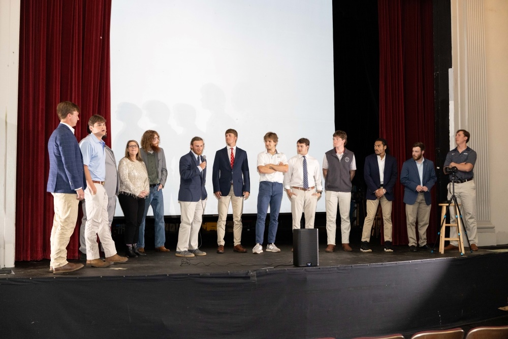 13 students standing onstage