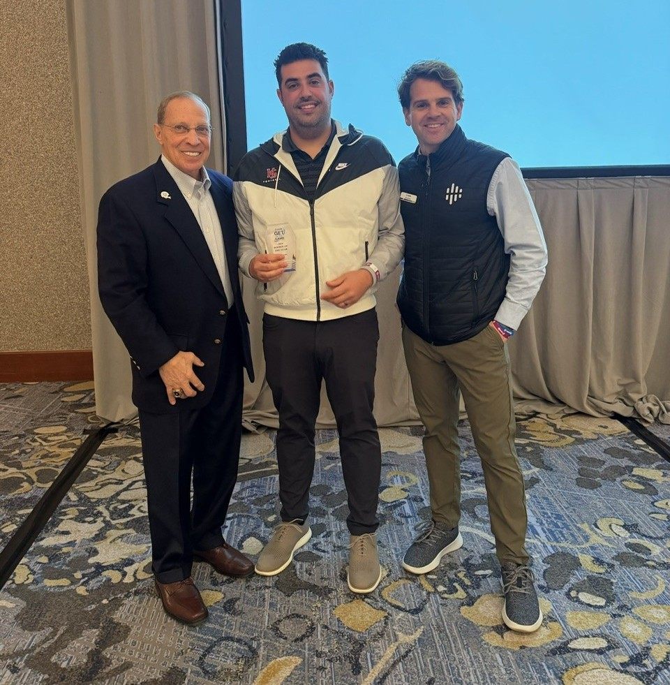 Football Coach Vince Luvara posing with Get in the Game officials
