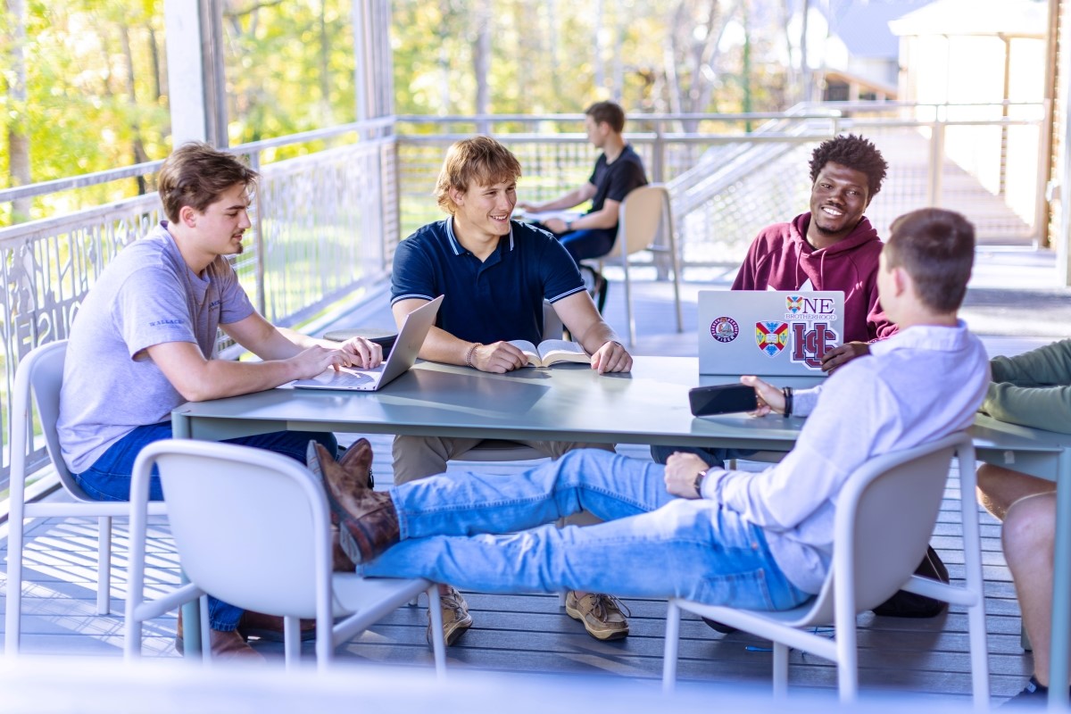 students hanging out on the porch of Whitehouse Dorm