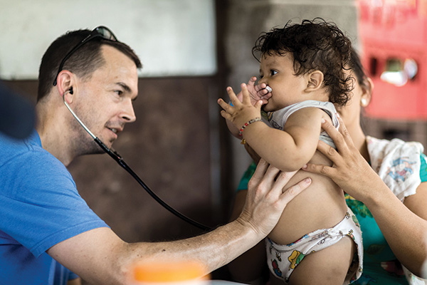 Jeff Mapp '01 examining a baby