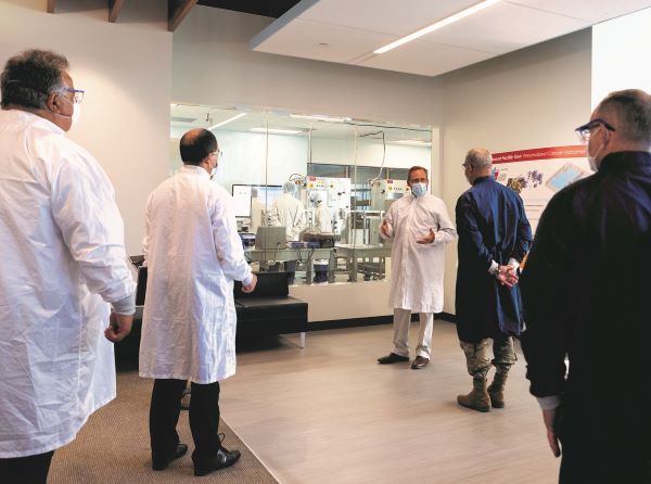 Scott Nickerson in a labcoat talking to a few people in a labcoat