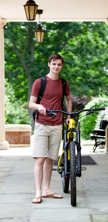 David Fluharty '20 with a bike in front of Bortz Library