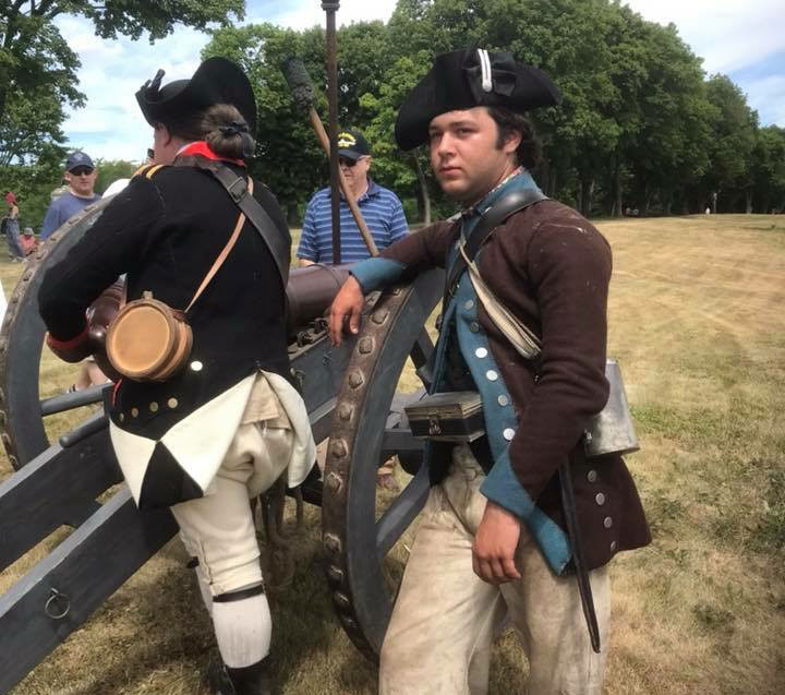 Lucas Hamby '22 as a Revolutionary War-era soldier standing by a cannon