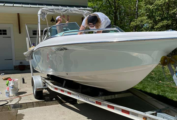 Ben Skinner and classmate cleaning and detailing a boat