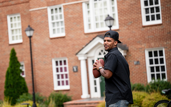 Kaleb Smith '22 throwing a football with friends