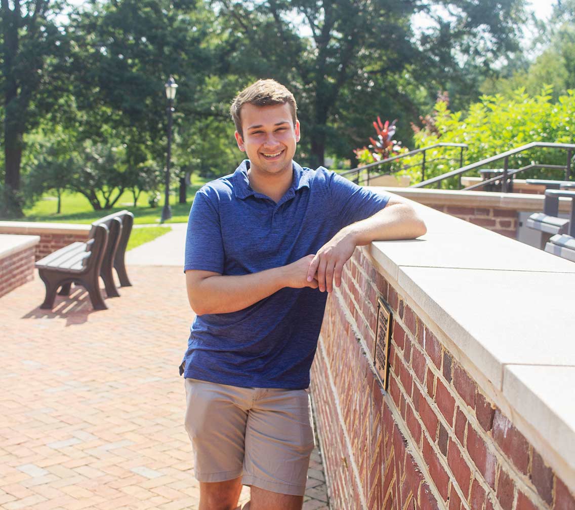 Taylor McGee '23 standing against a brick wall