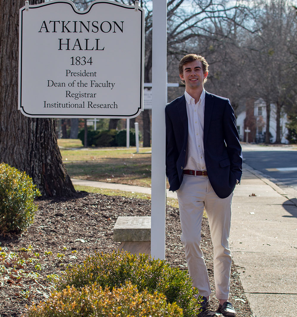 Andrew Parker standing beside a H-SC sign