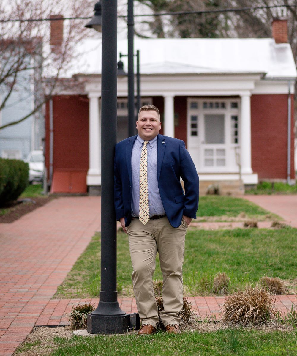 Grayson Manning standing by a lightpole in front of a building