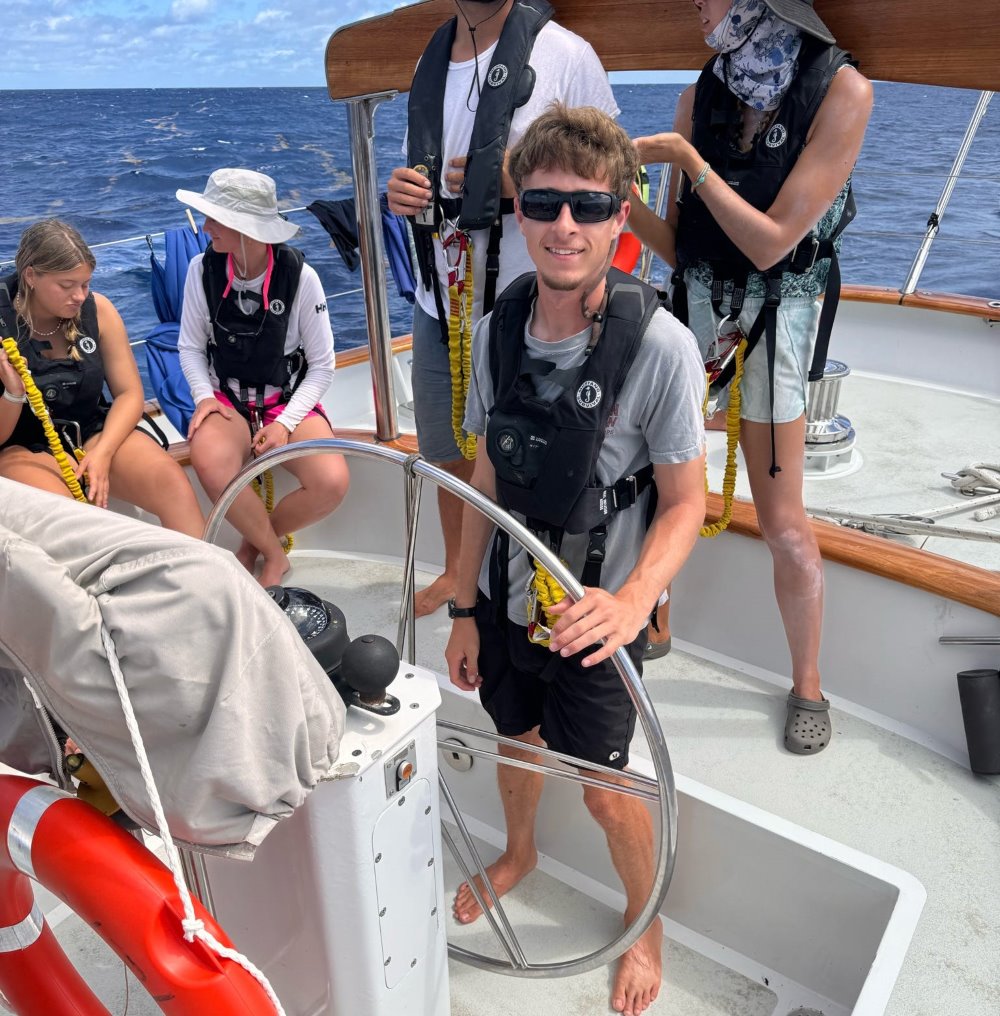 Watson Graber at the helm of a sailboat