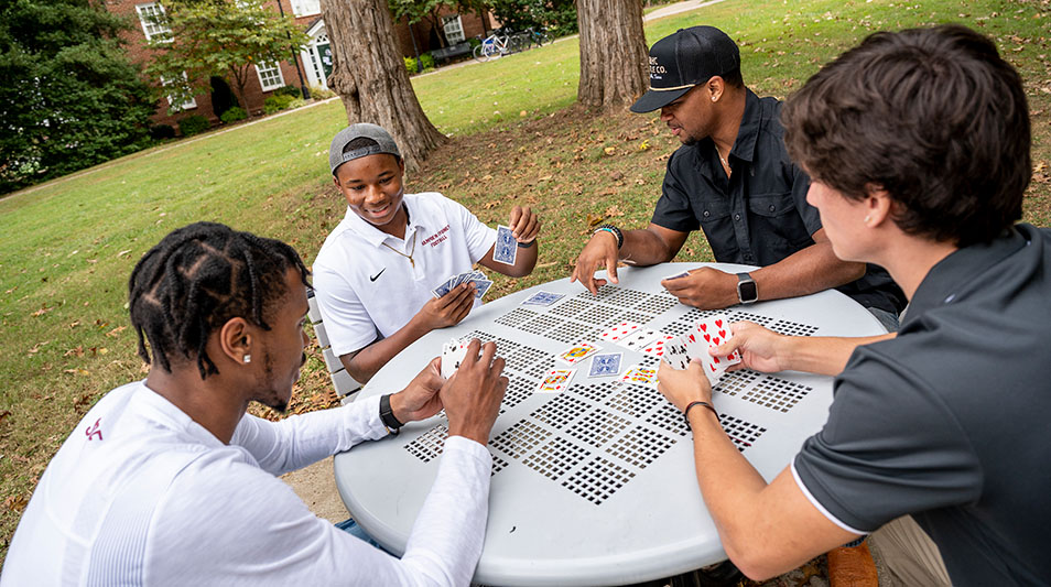 Hampden-Sydney College students playing cards at an picnic table