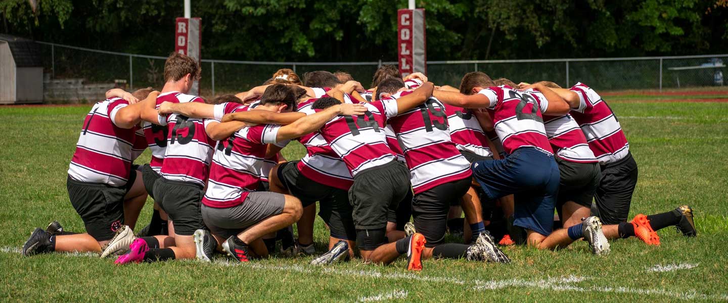 Hampden-Sydney College rugby team sharing a moment of focus on the field