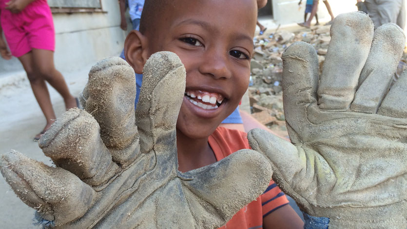 A child from the Dominican Republic wearing work gloves