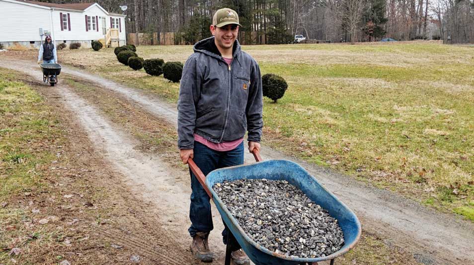 Hampden-Sydney student volunteers unloading gravel for the driveway of a Habitat for Humanity home