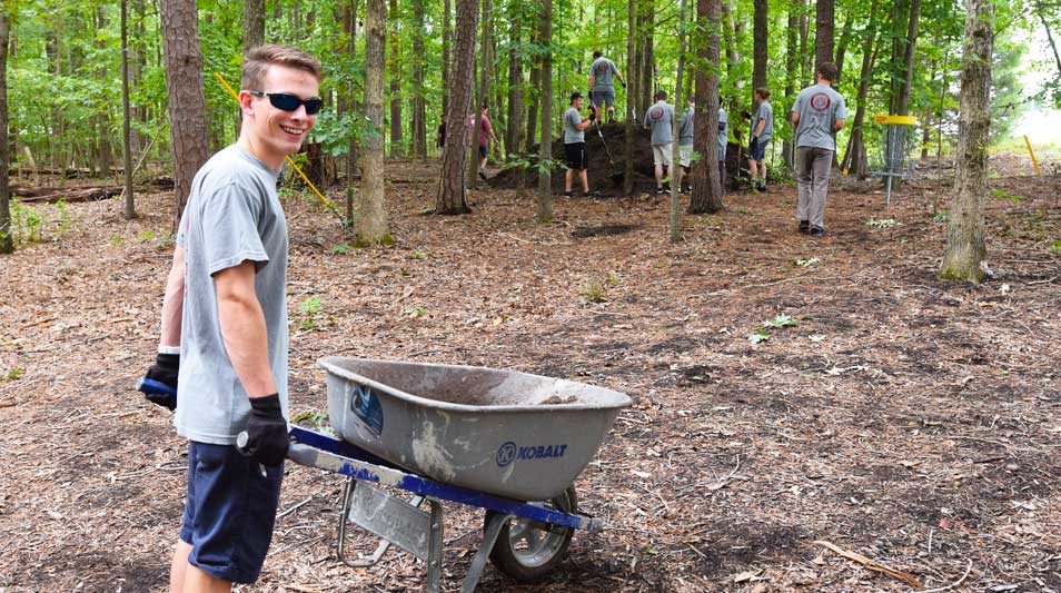 Students spreading mulch in the woods for Hampden-Sydney College's Tigers Serve