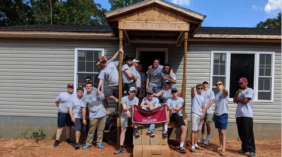 Hampden-Sydney College students standing in front of the Habitat for Humanity house that they helped build 