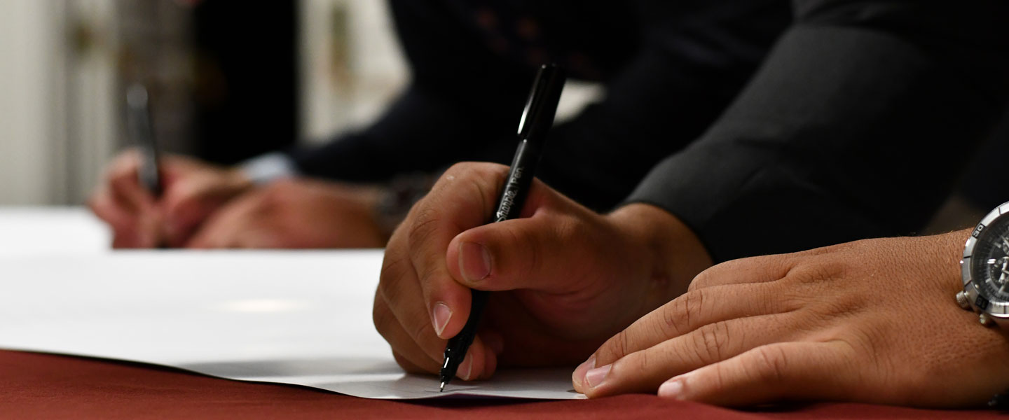 Hands filling out and signing forms Hampden-Sydney College