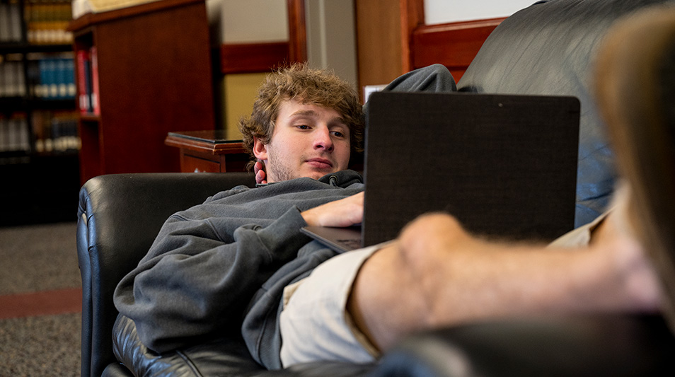 Student studying on a couch in the library
