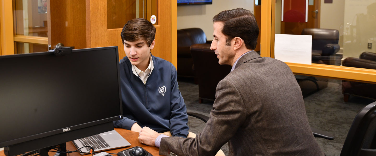 Dr. King with a student at his desk